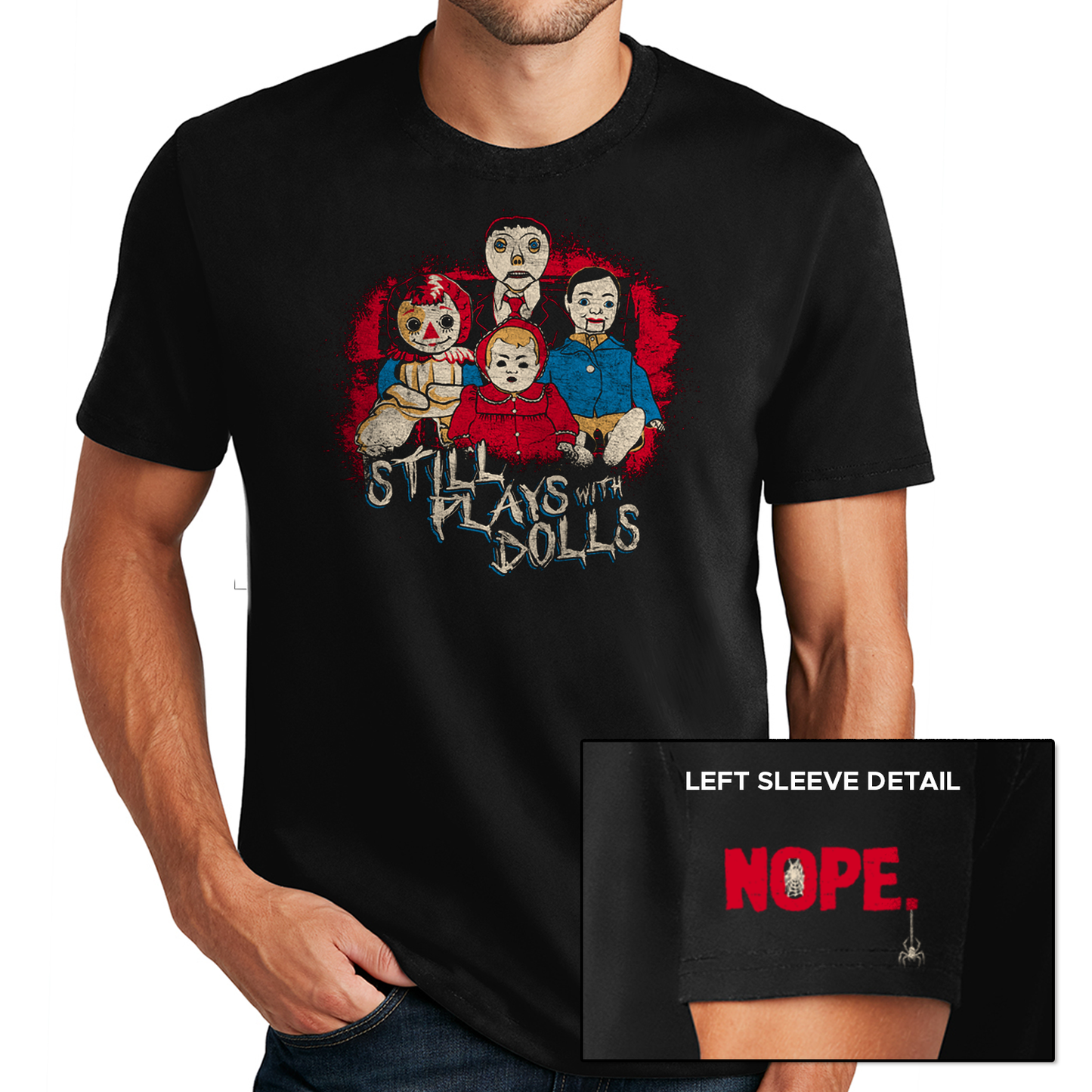 A male model wearing a black t-shirt against a white background. On the shirt is a collection of creepy dolls, surrounded by red spatters. Under the dolls is white text that says "still plays with dolls." At the bottom corner is a close up of the sleeve, with red text saying "NOPE" and a small spider hanging from the last letter.