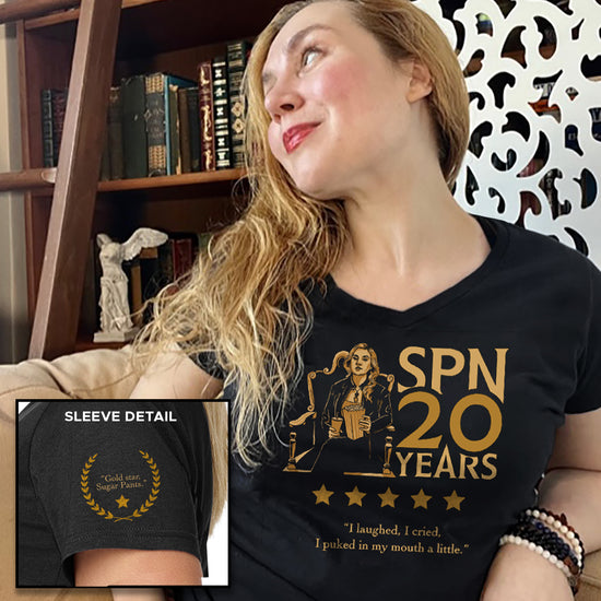 An image of actor Rachel Miner in a black and gold t-shirt. The front of the shirt has a gold image of Rachel's character Meg, seated in an ornate chair and holding a bucket of popcorn. Gold text says "SPN 20 years." Under the image are five gold stars, with text that says "I laughed, I cried, I puked in my mouth a little." An inset image shows the sleeve detail, with a gold laurel and text that says "gold star, sugar pants."