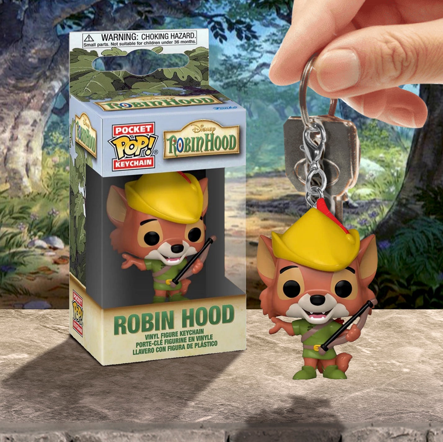Robin Hood keychain with packaging and a hand holding it against a forest background