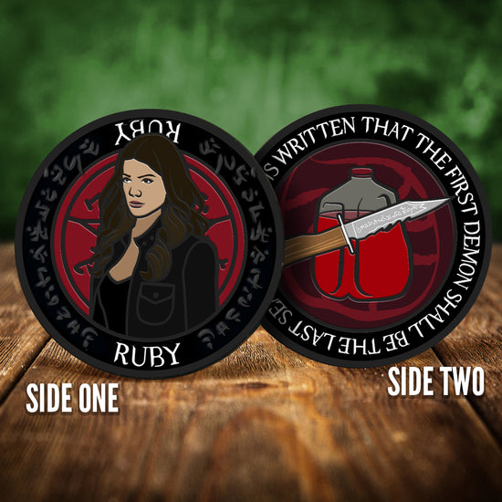 Front and back images of a challenge coin, side by side, on a wood table. The front depicts a drawing of Ruby. Behind her is a red devil's trap symbol. The back of the coin depicts a dagger in front of a gallon of blood, against a red background. White text around the edge says "And it is written that the first demon shall be the last seal."