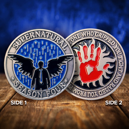 A brass coin charm with "Supernatural season four", a blue spark-filled background, and an angel sillhouette on one side and "I'm the one who gripped you tight and raised you from perdition" with a red handprint and anti-possession symbol on the other. The coins are on a wood table, with a blue background behind them
