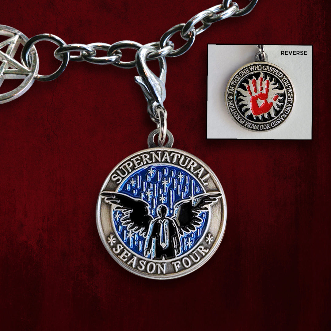 Front and back images of a brass charm. On the front is a black silhouette of Castiel against a blue background. On the back is a red handprint against a black background. Behind the charms is a red wall
