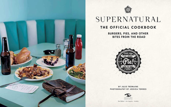 A two-page spread from the book. On the left are half-eaten meals on a light blue diner table, with beer bottles and a Hunter's journal next to the plates. On the right is the title page from the book, with black text saying "supernatural, the official cookbook: burgers, pies, and other bites from the road."