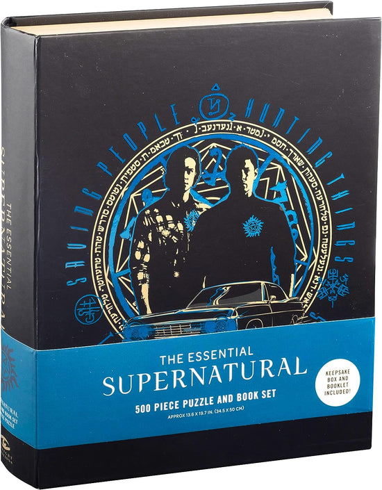 A black book on a white background. On the cover is a white and blue drawing of Sam and Dean Winchester, inside a circle with runes around the edge. Under them is a drawing of Baby. At the bottom is a blue banner with white text saying "The essential supernatural 500 piece puzzle and book set."