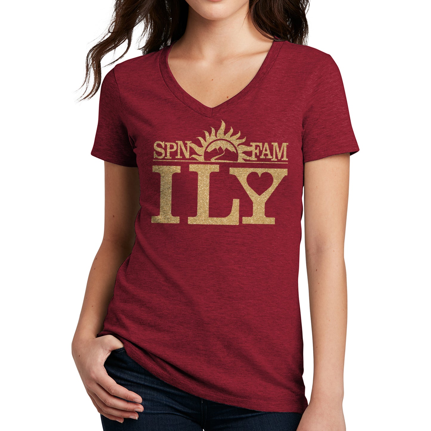 A female model in a dark red v-neck shirt. The shirt has gold text that says SPN FAM across the top, with ILY in larger font below. In the center is a rising sun image, with a road leading into the mountains.