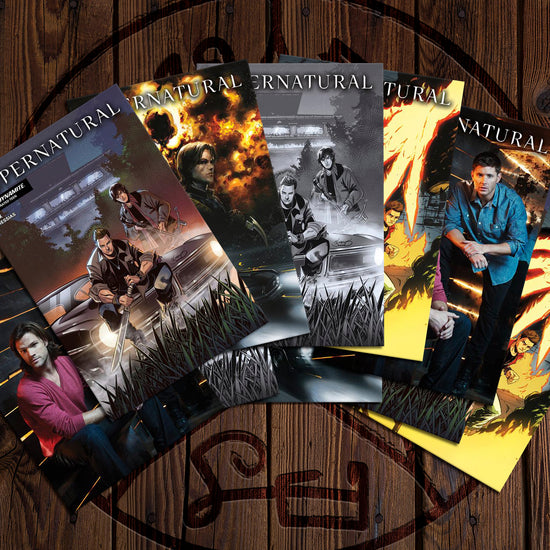 A collection of comic books on a wooden floor. Each comic depicts a different front cover of Supernatural Issue #1. Etched into the floor is a Devil's Trap symbol.