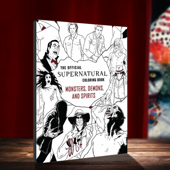 A black and white image of various monsters from the TV series Supernatural, with the Winchester Brothers at the top. In the center in black and red text is the title "The Official Supernatural Coloring Book: Monsters, Demons, and Spirits." The book is standing on a wood stage in front of a red curtain. Off to the side is a blurry, sinister clown.