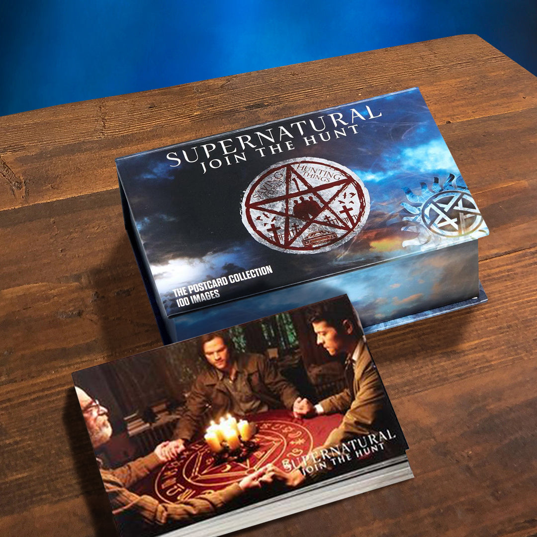 A blue postcard box on a wooden table. On the boxtop is white text saying "Supernatural: join the hunt." Below the text is the anti-possession symbol in white and red. Next to the box is a postcard are characters from the TV series Supernatural taking part in a seance.