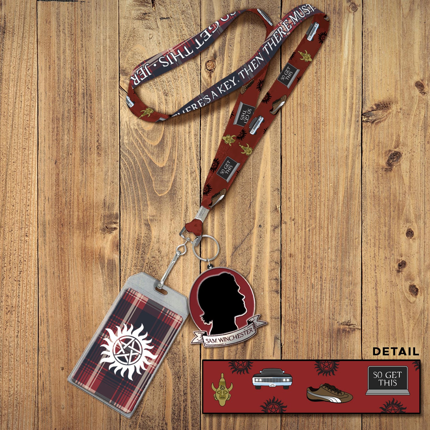 A red plaid landyard with white text saying "always keep fighting." Attached to the landyard is a pendant with Sam Winchester's face in silhouette. Behind the lanyard is a wooden table. In the bottom right corner is an inset image showing details of the strap, including drawings of a Samulet, a shoe, the anti-possession symbol, and a black Chevy Impala.