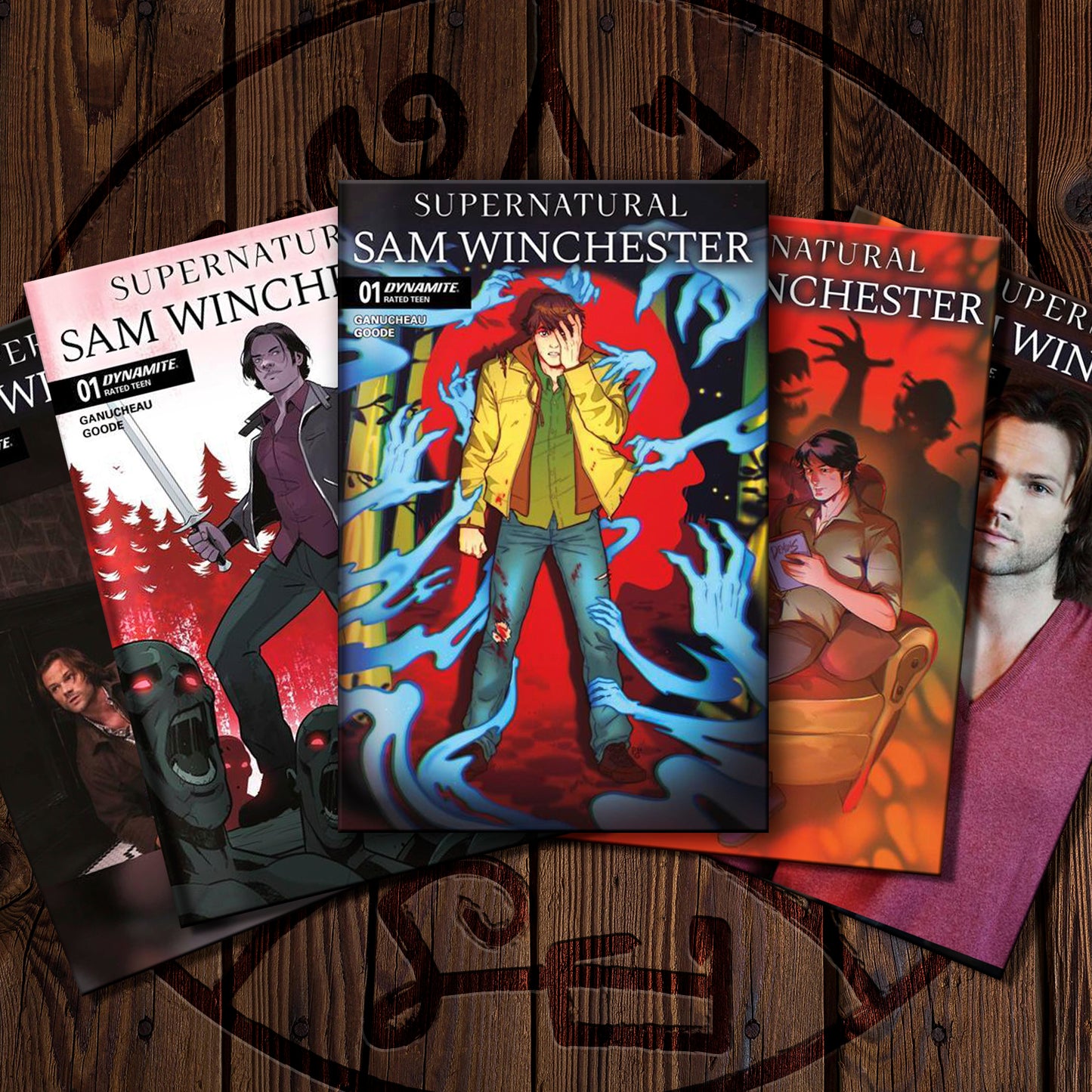 Five comic book covers fanned out on a dark wood surface, featuring the title 'Supernatural Sam Winchester' with illustrated covers in red, blue, orange, and black tones.