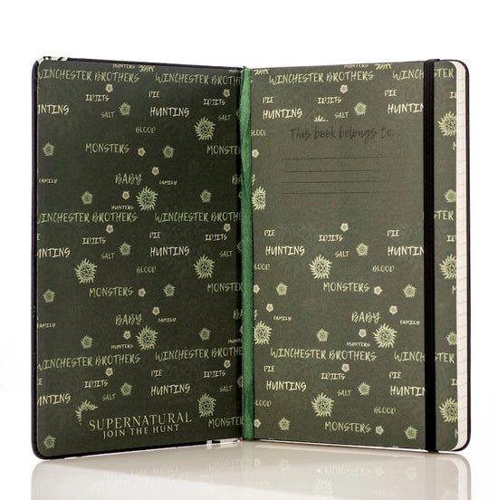 The inside of the journal, open to show the inside cover. White text covers the pages in random patterns, with names and phrases from the TV series Supernatural.