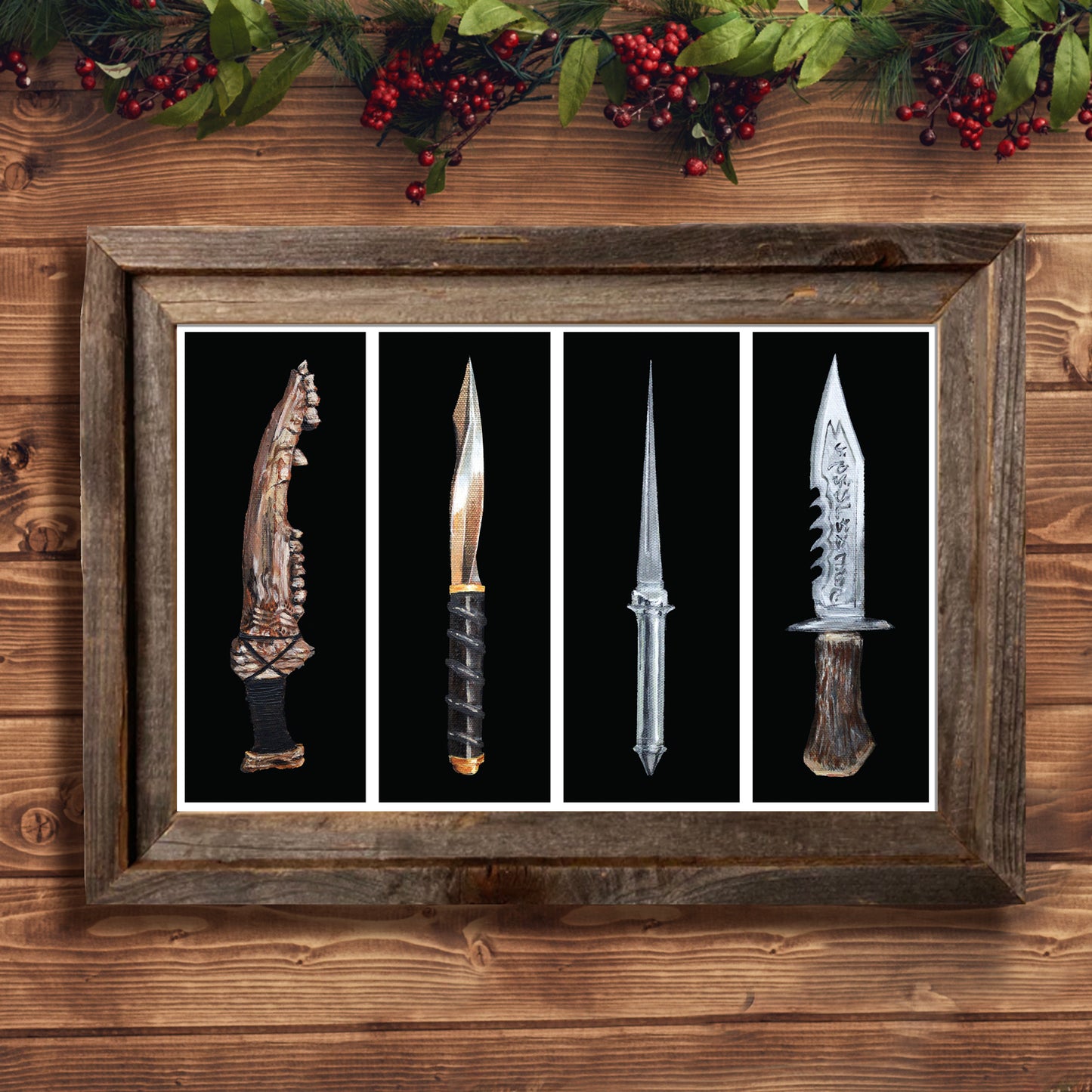 A lithograph in a wooden frame against a light wood wall. The lithograph depicts four knives from the TV series "Supernatural," First blade, archangel blade, angel blade, and Ruby's demon-killing knife. Each knife is against a black background with a white border. Above the frame is a garland of holly with red berries.