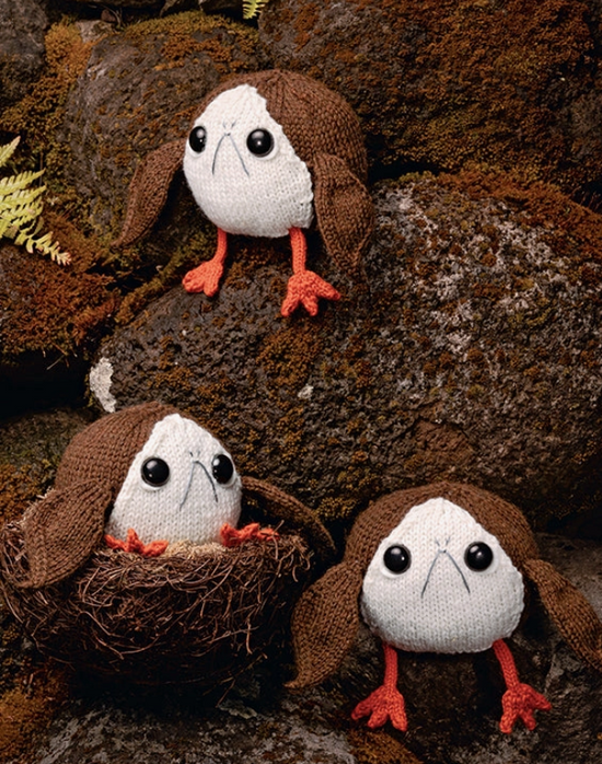 Knitted Porgs from the Star Wars movies, perched on moss-covered rocks.
