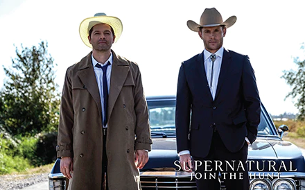 A postcard with an image of Dean Winchester and the angel Castiel from the TV series “Supernatural.” They are both wearing cowboy hats and standing in front of a black 1967 Impala. Behind them are trees and the bright sky.