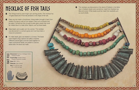 Load image into Gallery viewer, A parchment-colored book page with a red border. On the page in black text is the page title reading “necklace of fish tails,” with a description of the necklace underneath. On the right side is an image of an ancient necklace with multiple layers of beads and bronze pendants in the shape of fish tails.
