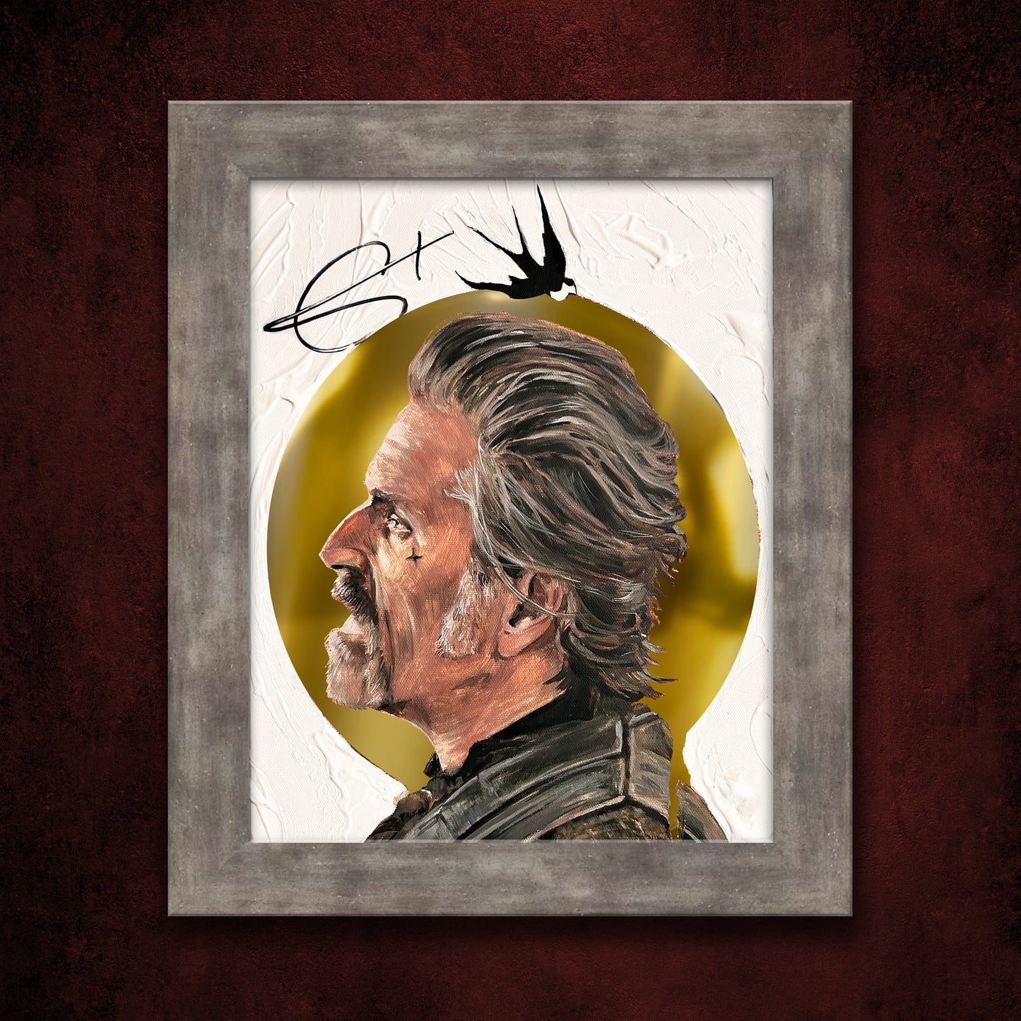 A framed lithograph against a dark red wall. The lithograph depicts the character Izzy from Our Flag Means Death, and is autographed by the actor Con O'Neill. The character's head is surrounded by a golden halo against a white background.