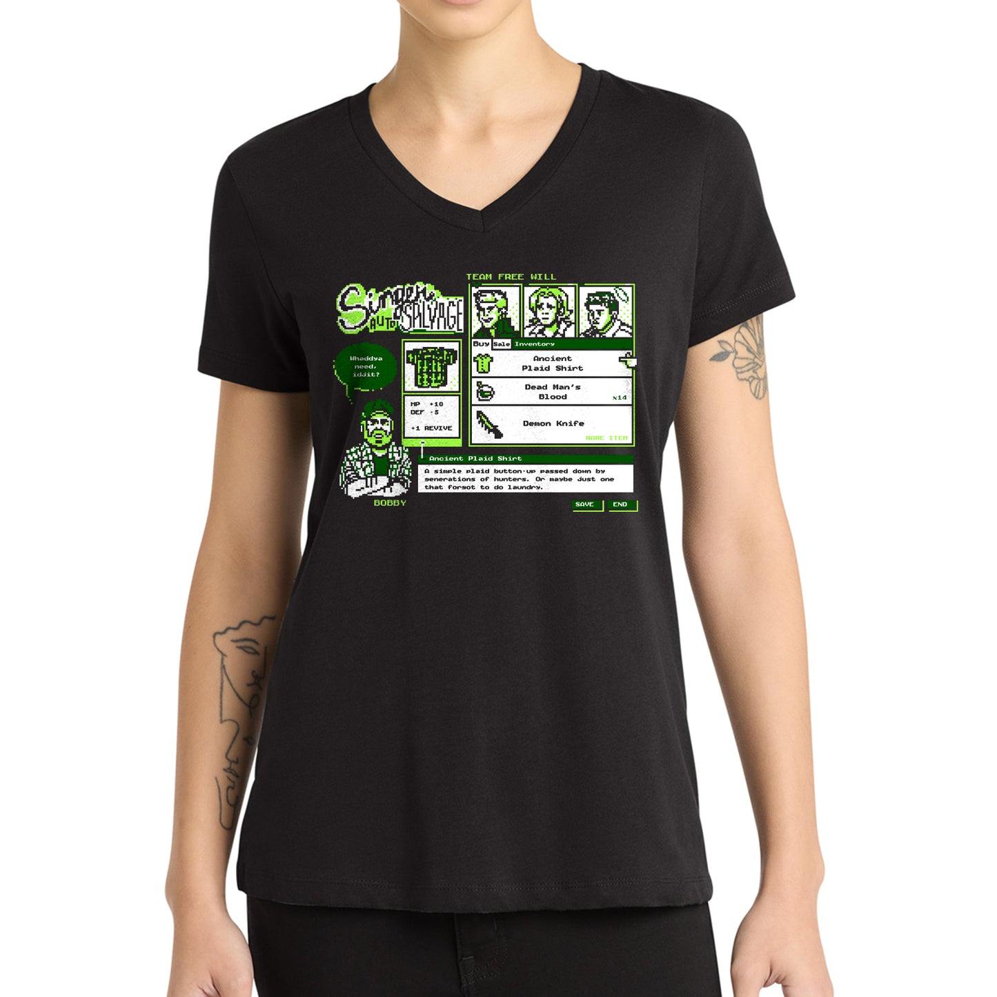 A woman wearing a black V-neck t-shirt with a green and white retro computer-style graphic on the chest depicting a character named 'Spooktacular'.