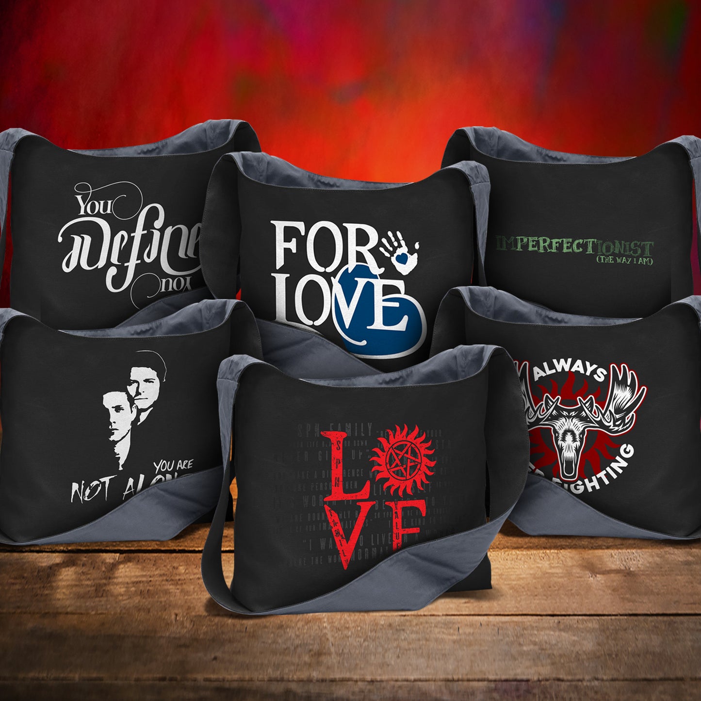 Collection of black bags with various designs and text on a wooden surface with a fiery background.