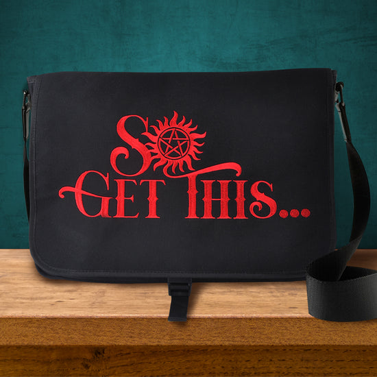 A black messanger bag on a wood table, against a chalkboard. The front of the bag has red test saying "So Get this...." The O in the word So is the anti-possession symbol.