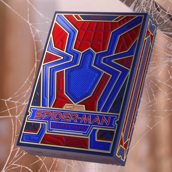 A red and blue box of playing cards caught in a spiderweb. The box depicts the Spider-Man symbol.