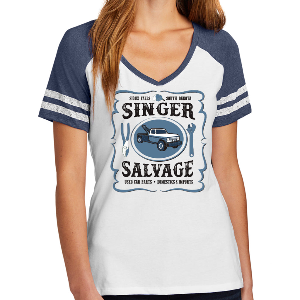 A female model wearing a white V-neck shirt with blue sleeves. The design on the front of the shirt says "Sioux Falls * South Dakota - SINGER SALVAGE - Used Car Parts * Domestics & Imports" with a tow truck in the center and two tools on either side.