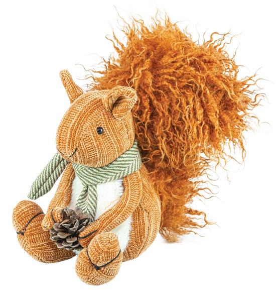 A stuffed squirrel with a bushy orange tail, against a white background. The squirrel is wearing a green and white striped scarf, and is clutching a pine cone in its front paws.