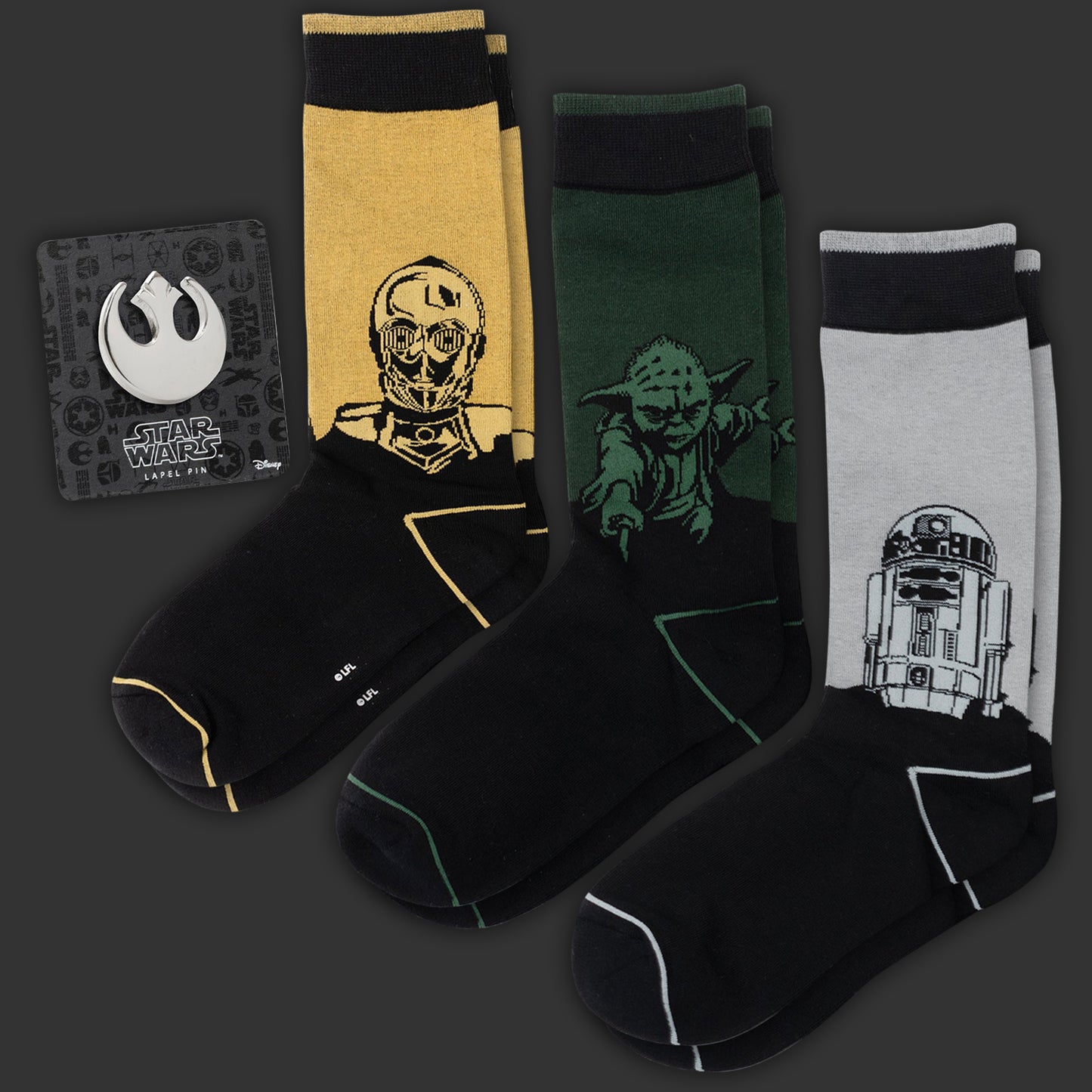 Three Star Wars-themed socks with character designs on a dark background. A Rebel Alliance lapel pin is next to the socks