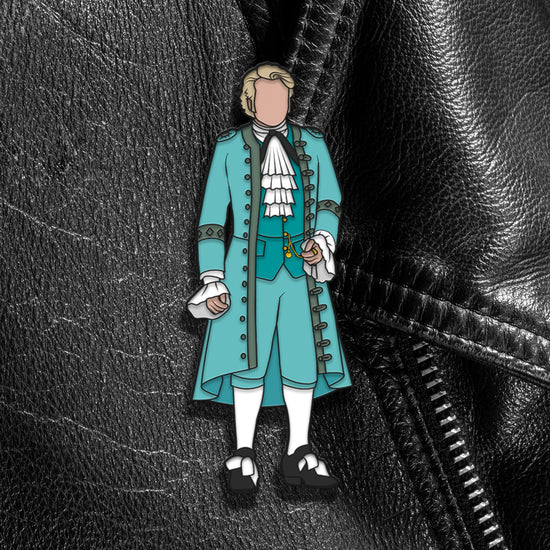 A pin depicting a gentleman in light blue finery, against a black leather jacket.