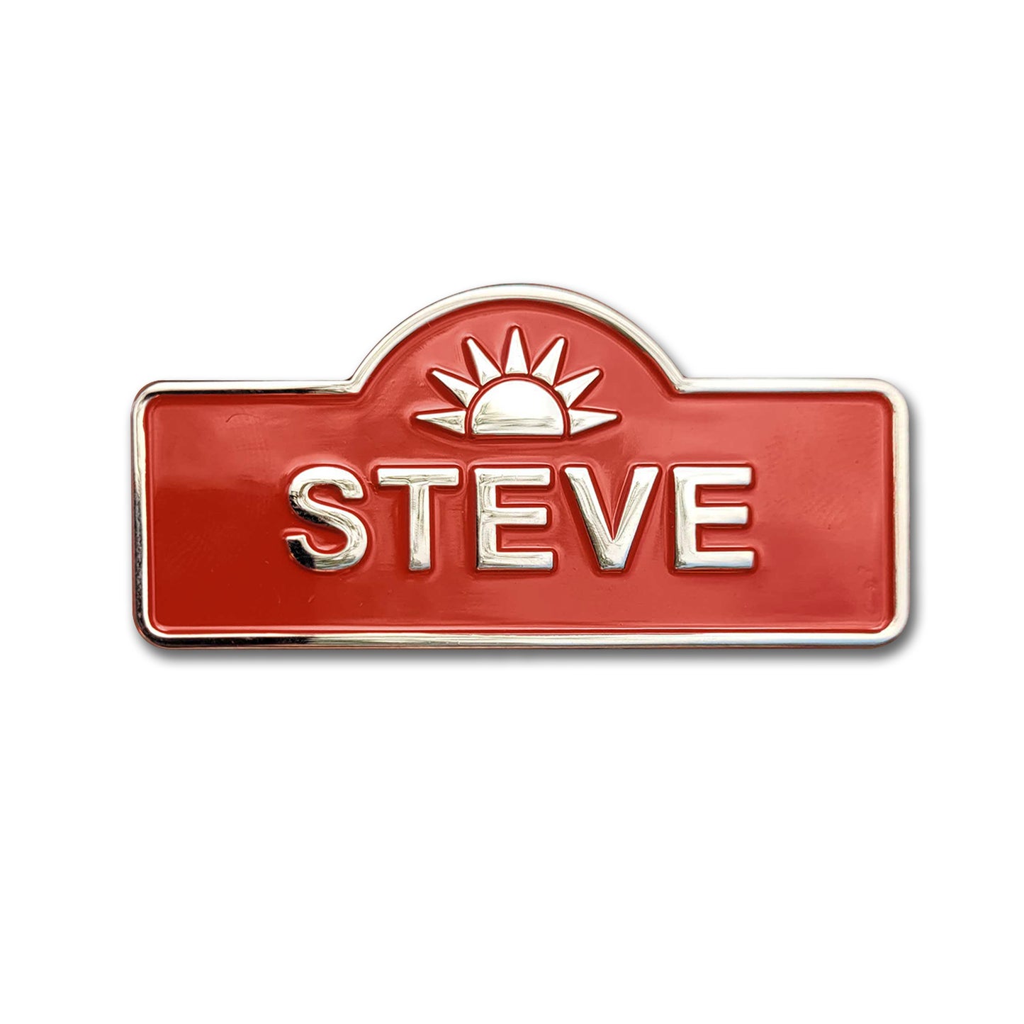A brass pin in the shape of a name tag. A rising sun is at the top, with the name "STEVE" printed below.