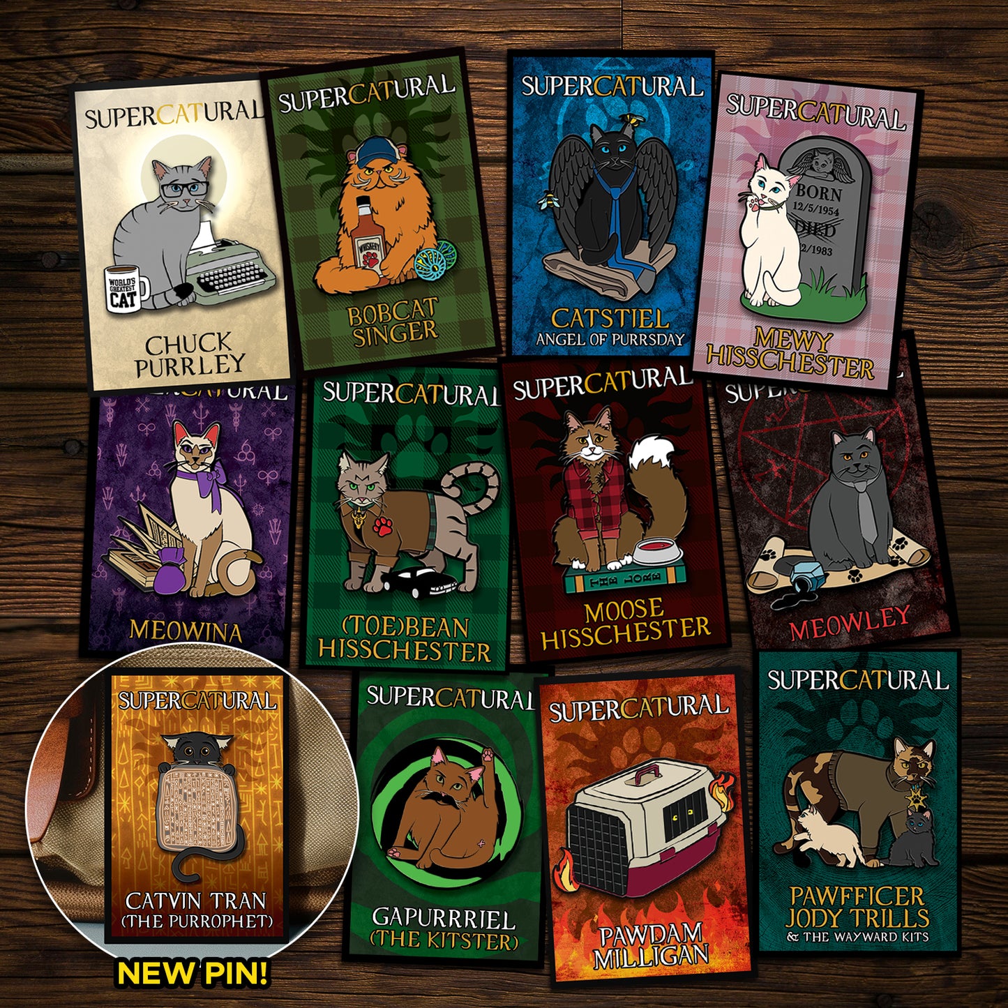 A collection of enamel pins on a wooden table. Each pin depicts a character from the TV series "Supernatural" reimagined as cats. An inset in the bottom left corner reads "NEW PIN!" and has an image of Catvin Tran, the newest pin.