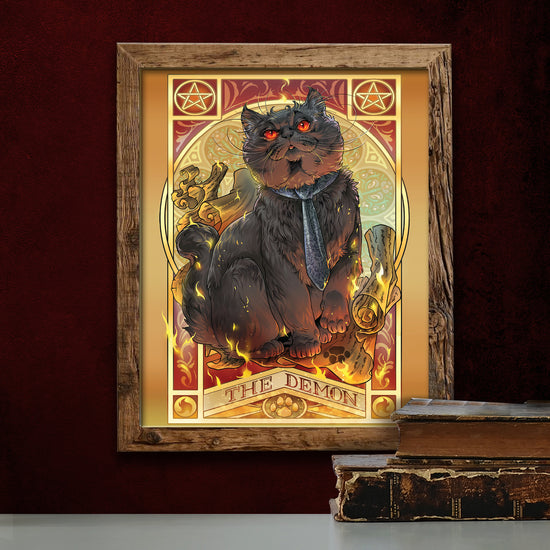 A drawing of a black cat sitting on a scroll, surrounded by flames. At the top corners are pentagrams. Under the cat is yellow text that says "The Demon." The cat is wearing a dark blue tie, and has glowing red eyes. Below the drawing is a stack of old books on a table.