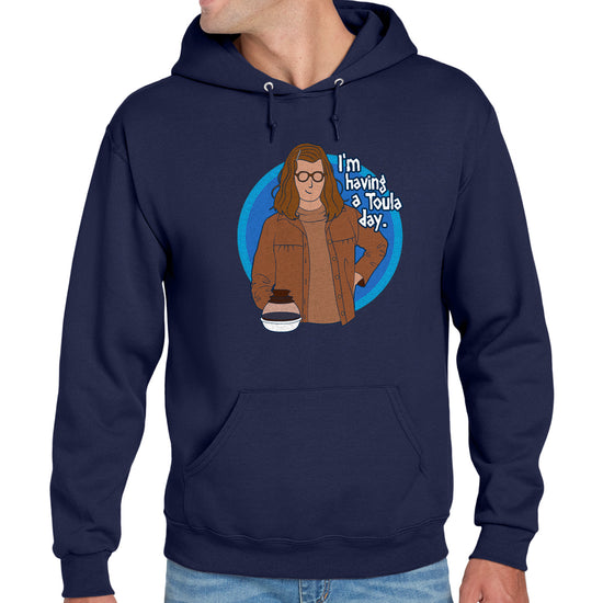 Navy blue hoodie with a graphic of a person in a brown jacket and text 'I'm having a Toule's day' on a white background.