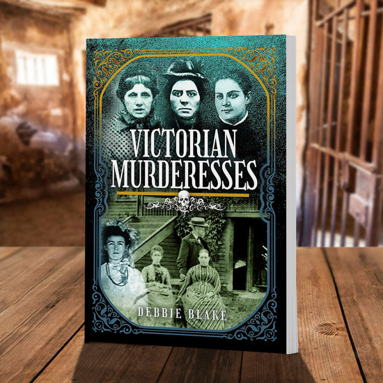 A blue book on a wooden table. Across the book cover are black and white photographs of women in Victorian-era clothing. At the center of the cover is white text saying "Victorian murderesses." Behind the book are old jail cells with stone walls.