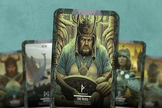 A collage of Viking-themed tarot cards on a teal background. The center card depicts a Viking in a forest, cradling his shield. Under the drawing is a white nordic rune, with the meaning and description included.