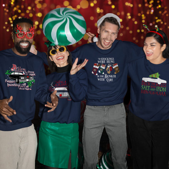 Four models wearing blue sweatshirts, standing against a backdrop of holiday lights. Each model's shirt depicts a different Supernatural-themed design. A green and white striped balloon floats in the air above one of the models.