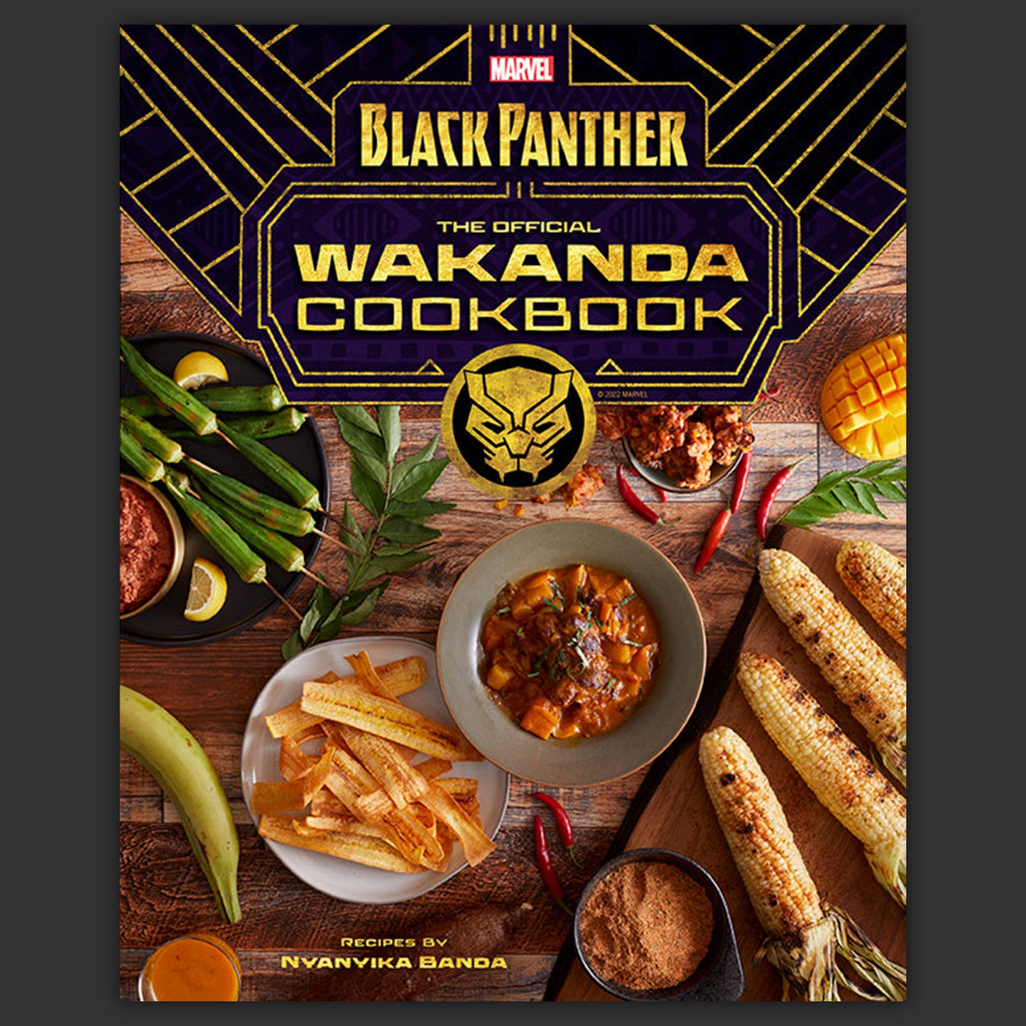 Black Panther The Official Wakanda Cookbook with food images on a wooden background
