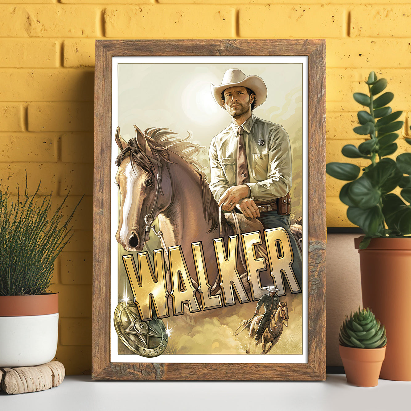 A framed drawing of the character Walker, portrayed by actor Jared Padalecki, on horseback. Under the horse is gold text saying "walker," with a sheriff's badge next to it. Behind the drawing is a yellow wall, and potted cacti are on either side.
