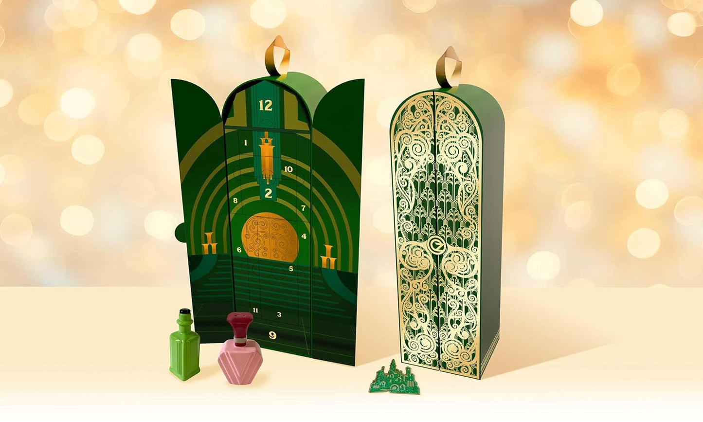 A green advent calendar against a gold background. The advent calendar depicts the gates of Emerald City from the movie "Wicked." Sitting in front of the calendar are a few Wicked-themed items.