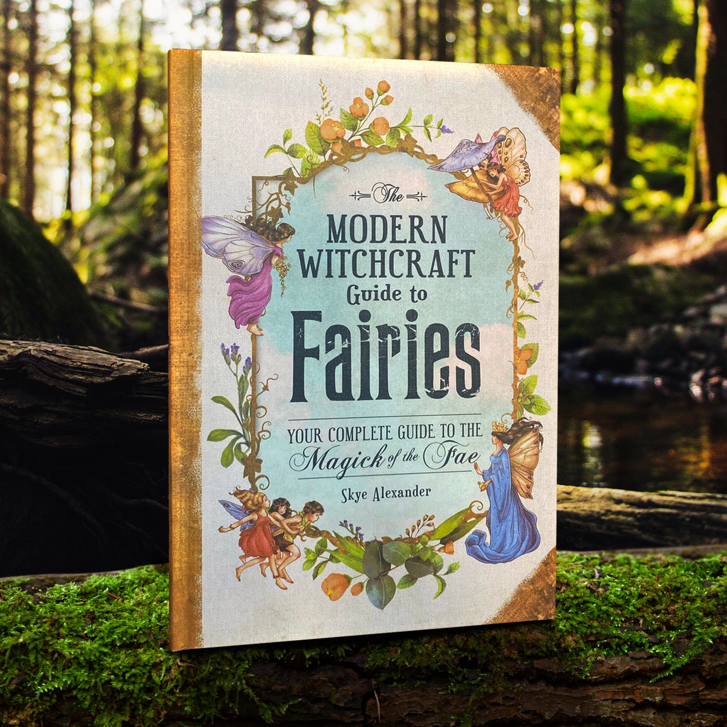 A hardcover book standing on a grassy tree limb. On the cover are old-fashioned drawings of flowers and fairies. In the center is an image of a blue sky with white clouds. Black text says "The modern witch craft guide to fairies. Your complete guide to the magick of the fae." Behind the book is a meadow with a pond in the middle.