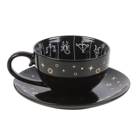 Black cup and saucer set with star and zodiac symbol design on a white background