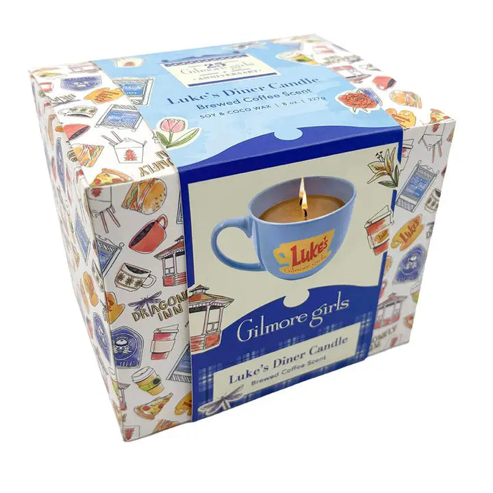 A cardboard container covered with drawings from the TV series "Gilmore Girls." On the front is an image of a blue coffee cup with "Luke's diner, Gilmore Girls" on the front in red. Inside the cup is a coffee-colored lit candle.