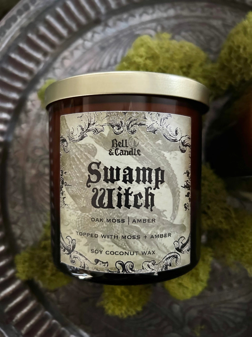 Candle jar labeled 'Swamp Witch' on a textured surface