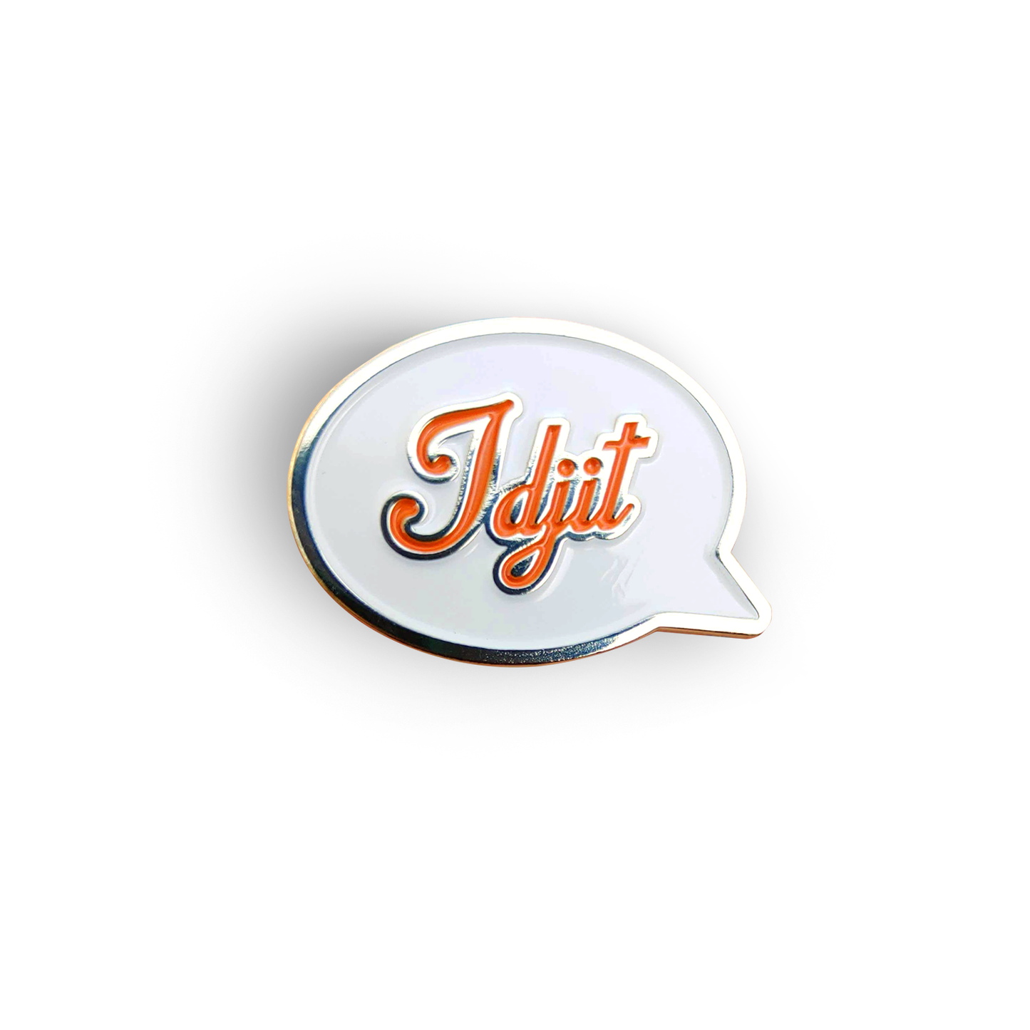 A silver pin with a white front in the shape of a speech bubble. The word "Idjit" is written in orange script font.