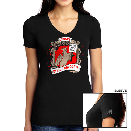 A female model wears a black v-neck t-shirt with an illustration of a jersey devil goat holding up a sign that says "You're doing great!" and a title adorning it that says "Jersey Devil's Advocate. The left shoulder has the word LORE written in white.