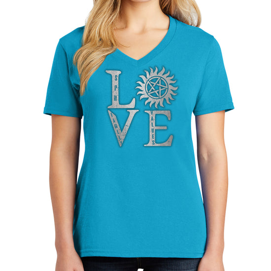 A female model wearing a turquoise v-neck shirt The front of the shirt has silver text saying "love," with the "O" replaced by the anti-possession symbol.