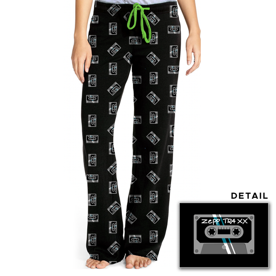 A pair of pajamas pants with a green tie string and covered in "mix tapes" - the mix tape is a cassette tape that says "Zepp Traxx" on it.