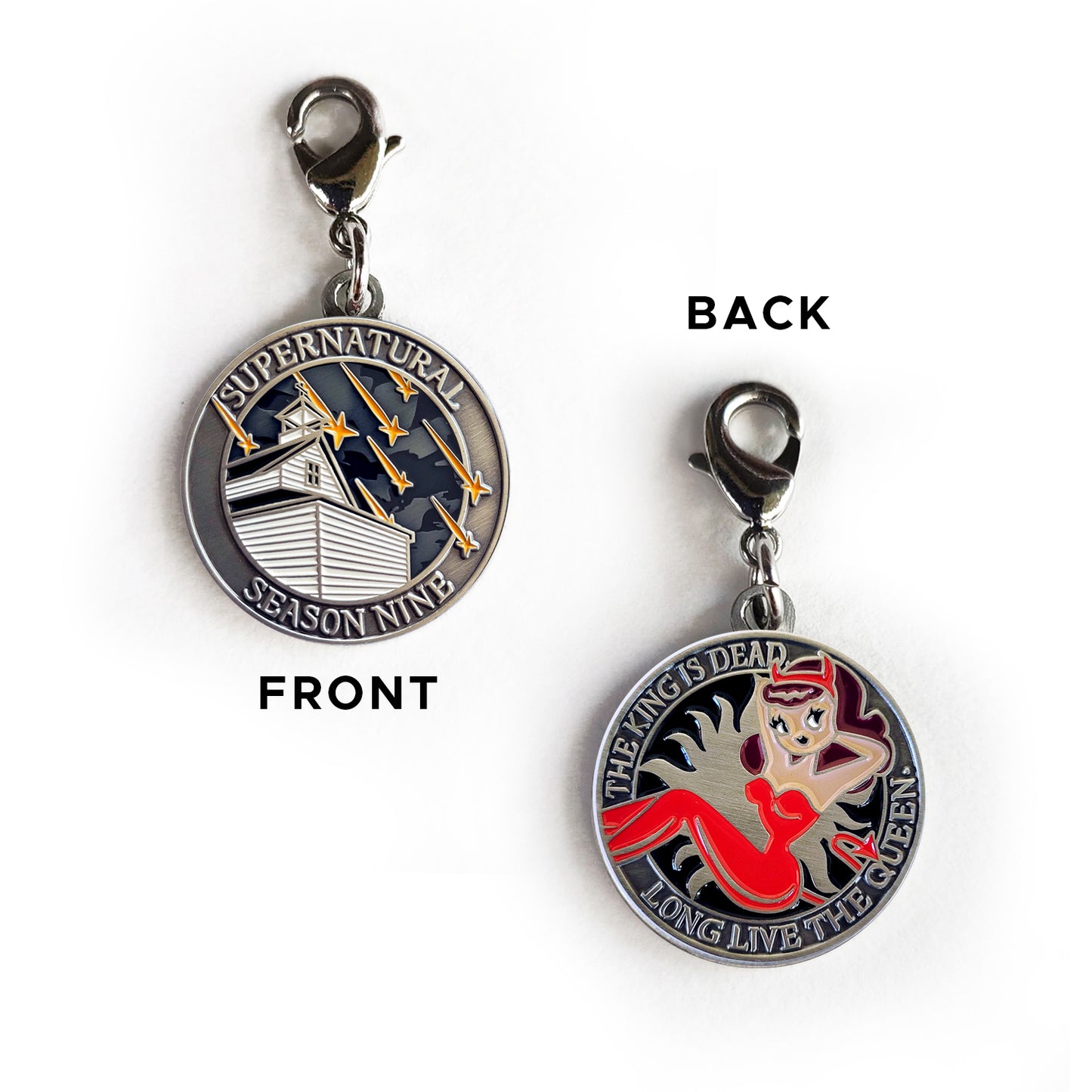 A brass charm with "Supernatural season nine", a church with falling stars on one side, and "The king is dead, long live the queen.", and a woman in a red jumpsuit with devil horns and a devil tail  with an anti-possession symbol background on the other.